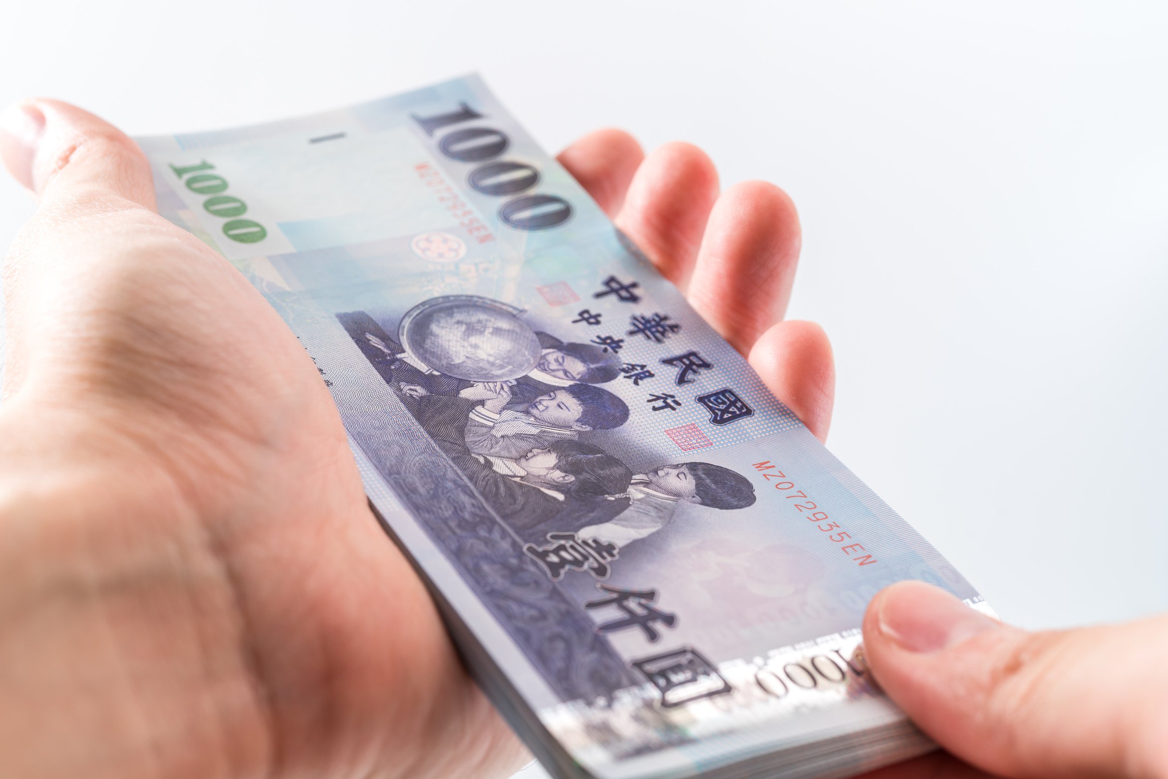 A Hand Holding a 1000 New Taiwan Dollar Bill.